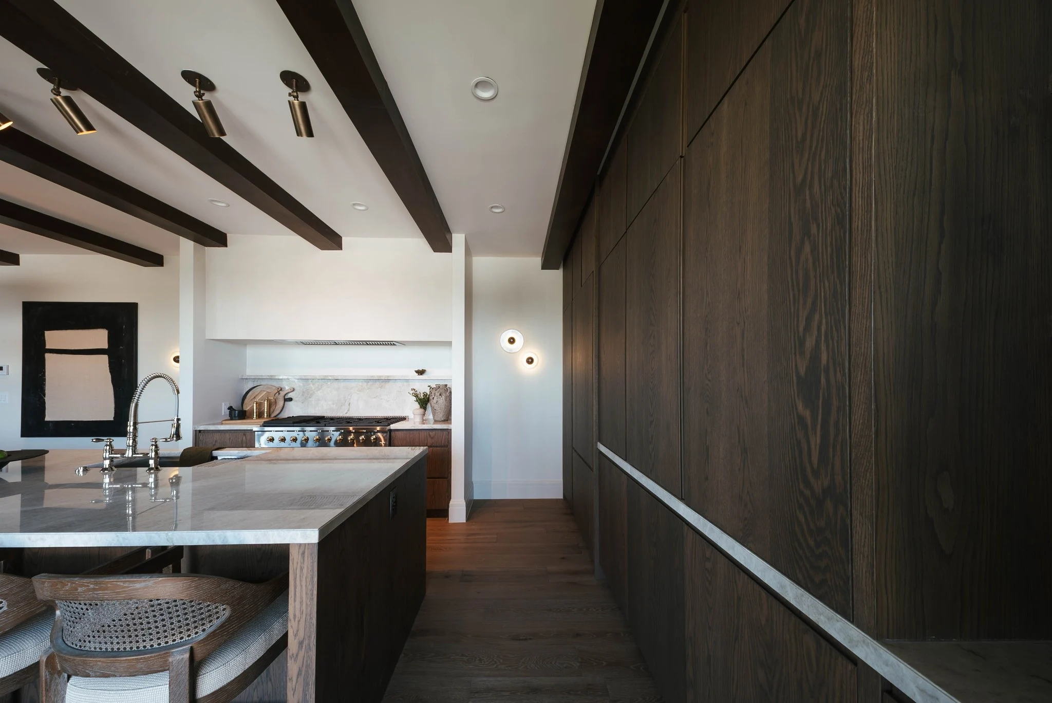 Oak kitchen cabinetry, stone island, and exposed ceiling beams