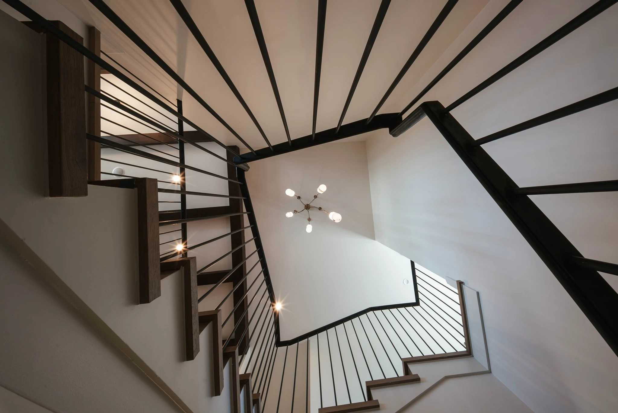 Sculptural stairwell with dark linear railings
