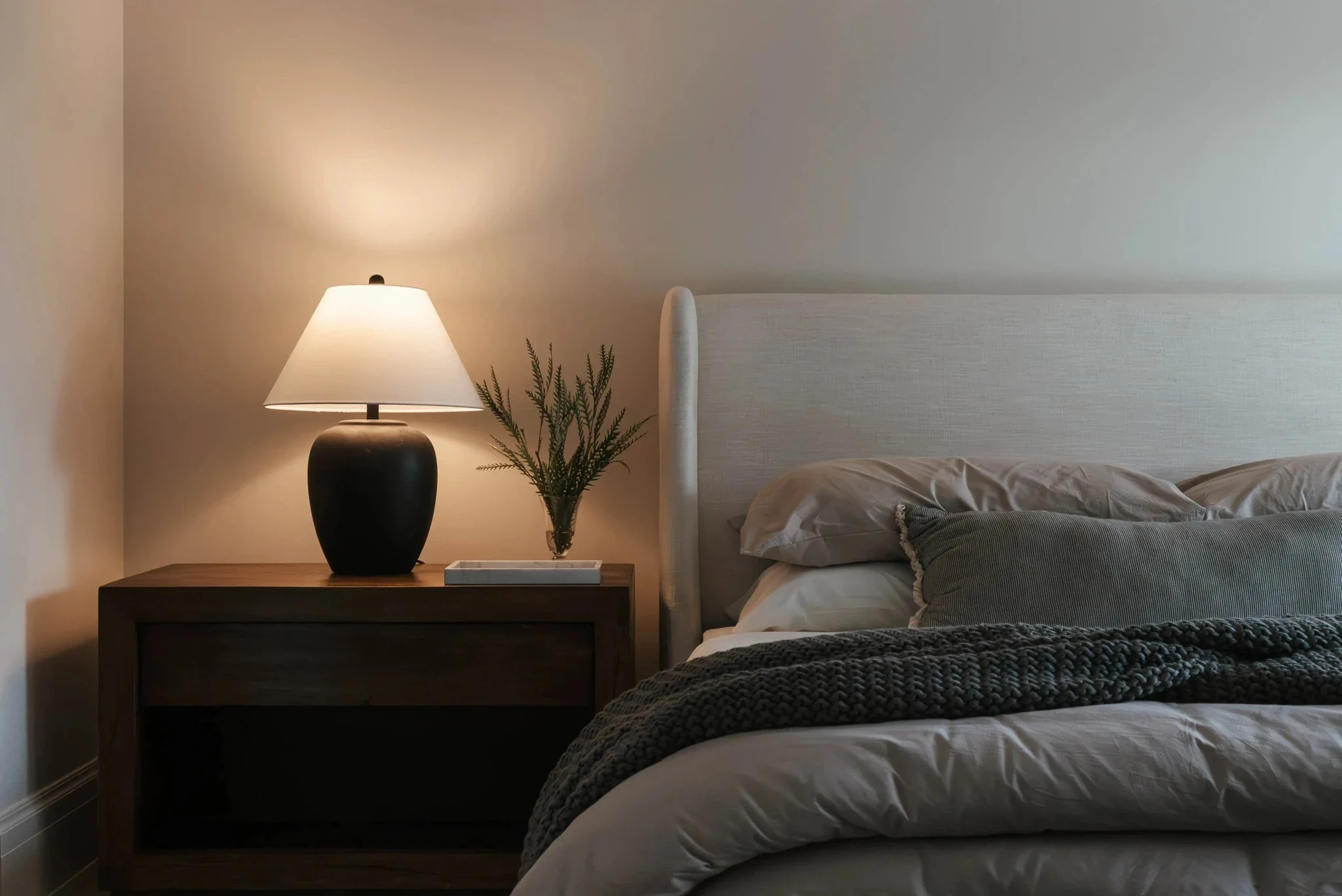 Bedroom with warm lamp light and dark timber furniture