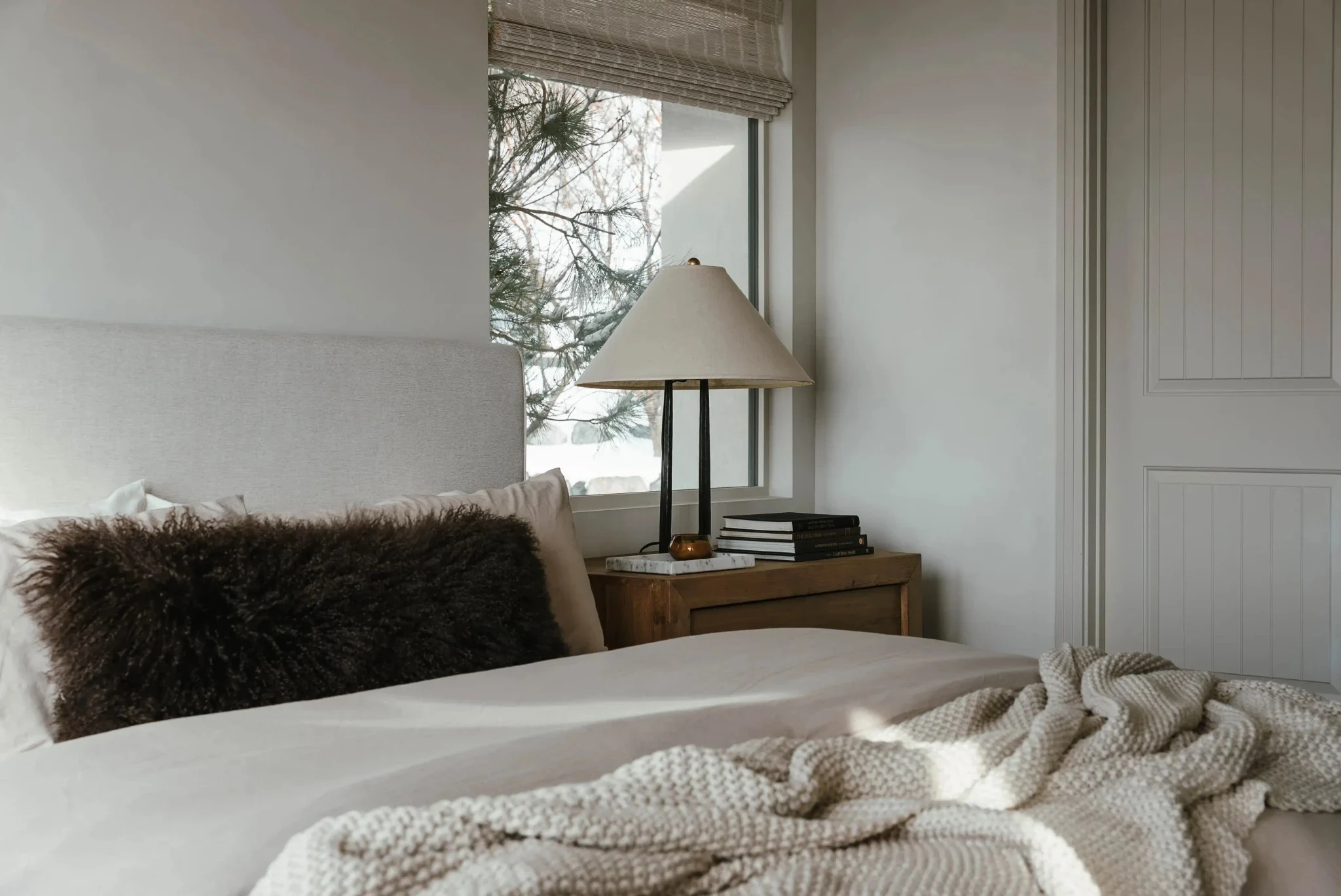 Bedroom with upholstered headboard and layered natural textures